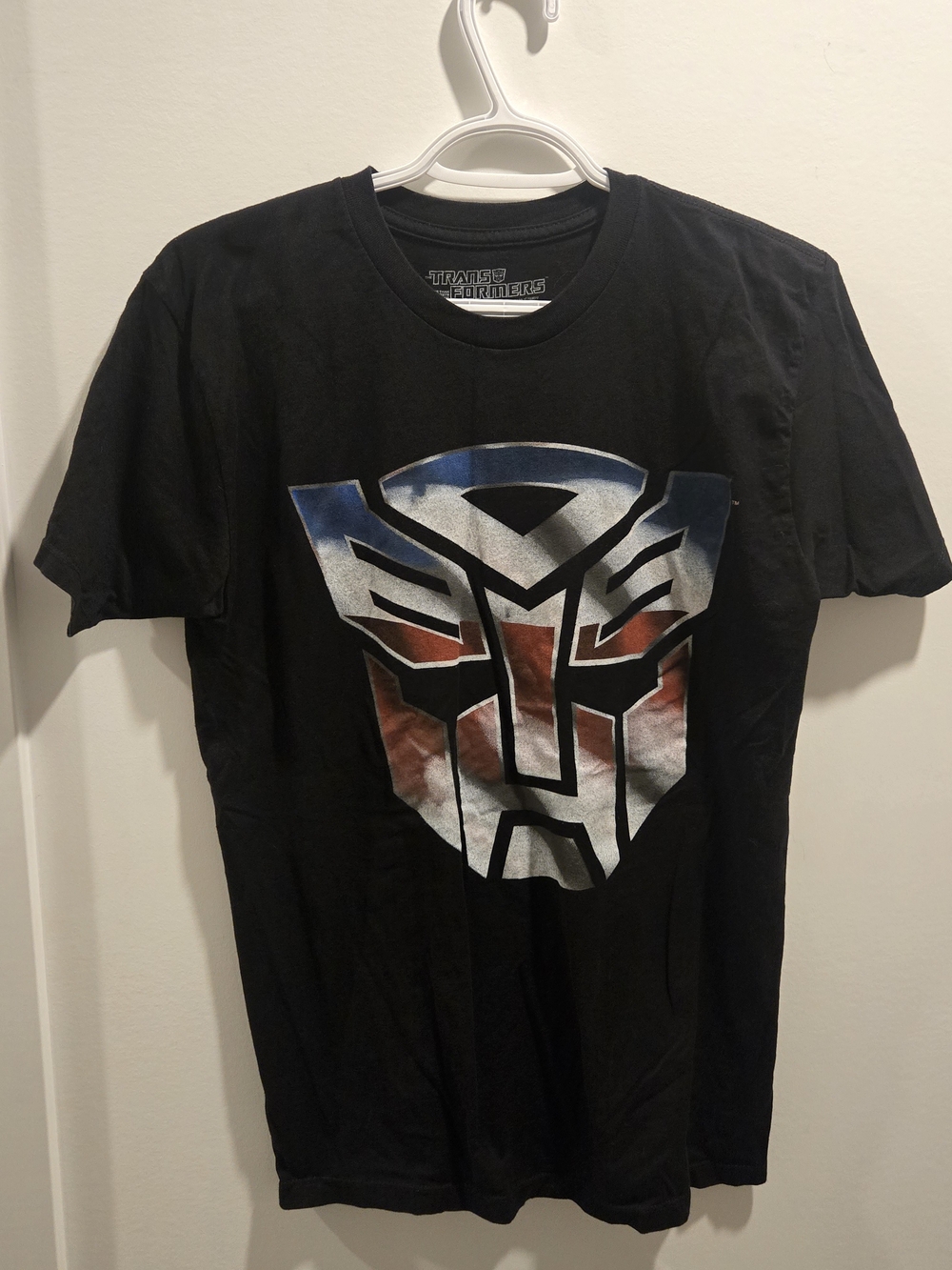 Hasbro Black Tee with Red, Blue and Silver Transformers Emblem